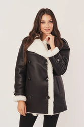 Woman wearing a black leather jacket with white fur trim on a white background