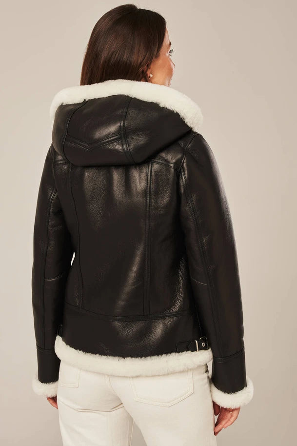 Black leather jacket with white fur lining worn by a person on a neutral background