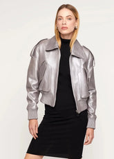 Woman wearing a silver metallic jacket over a black outfit on a white background