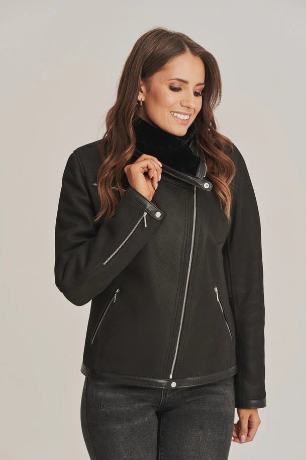 Woman wearing a black jacket with a plain background