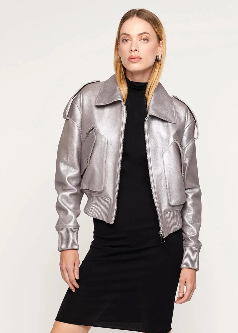 Woman wearing a silver metallic jacket over a black outfit on a white background